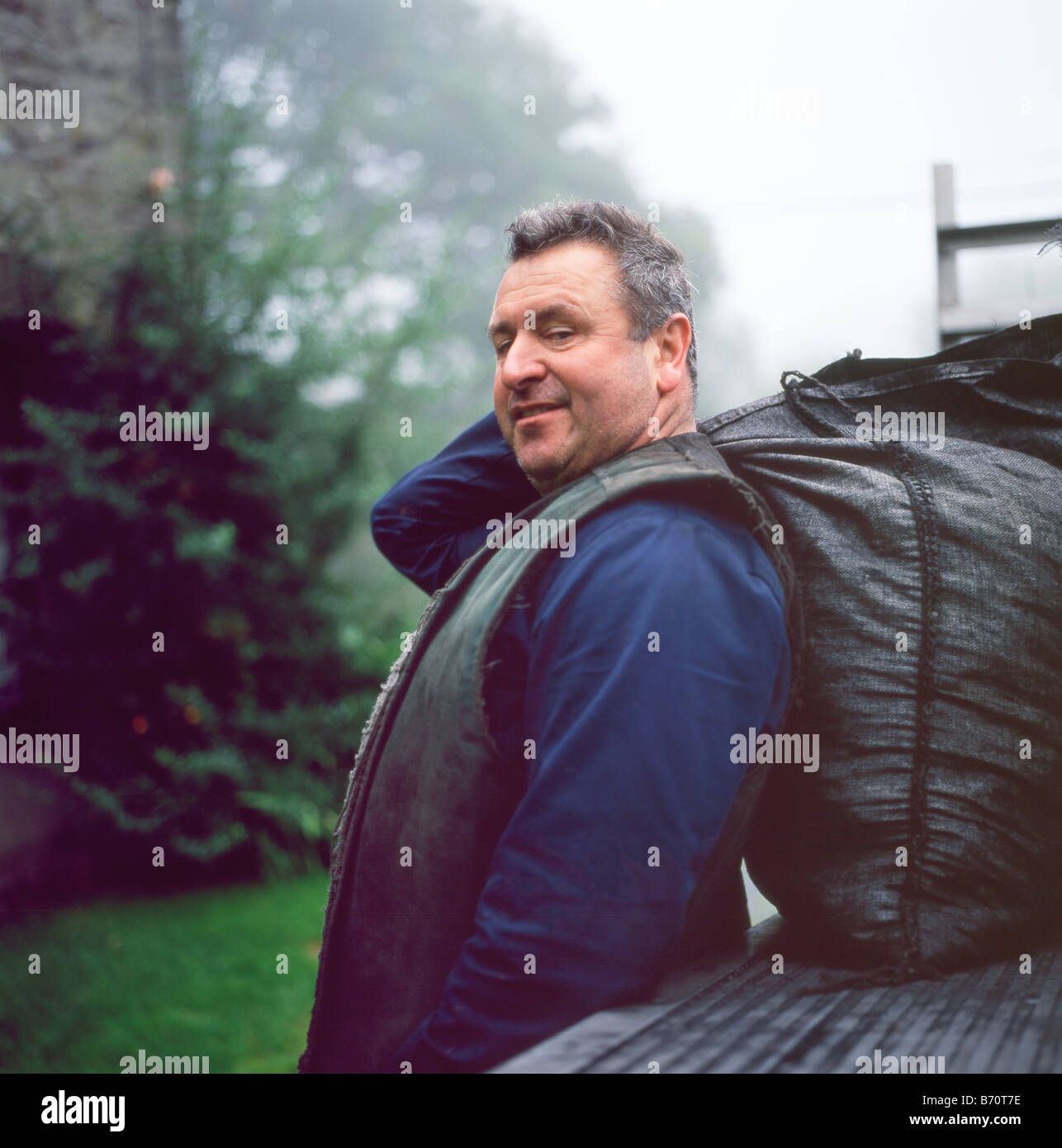 Portrait of coal man Robert Brown of Sennybridge delivering coal sack for solid fuel stove in Llanwrda Carmarthenshire Wales UK BritainKATHY DEWITT Stock Photo