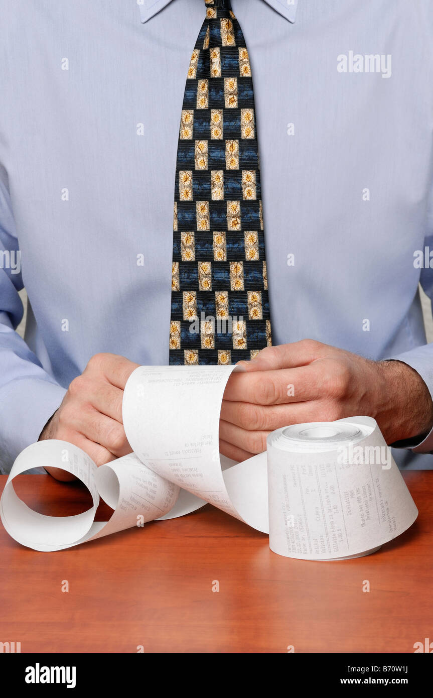 Businessman Looking Through a Receipt Roll Close Up Stock Photo