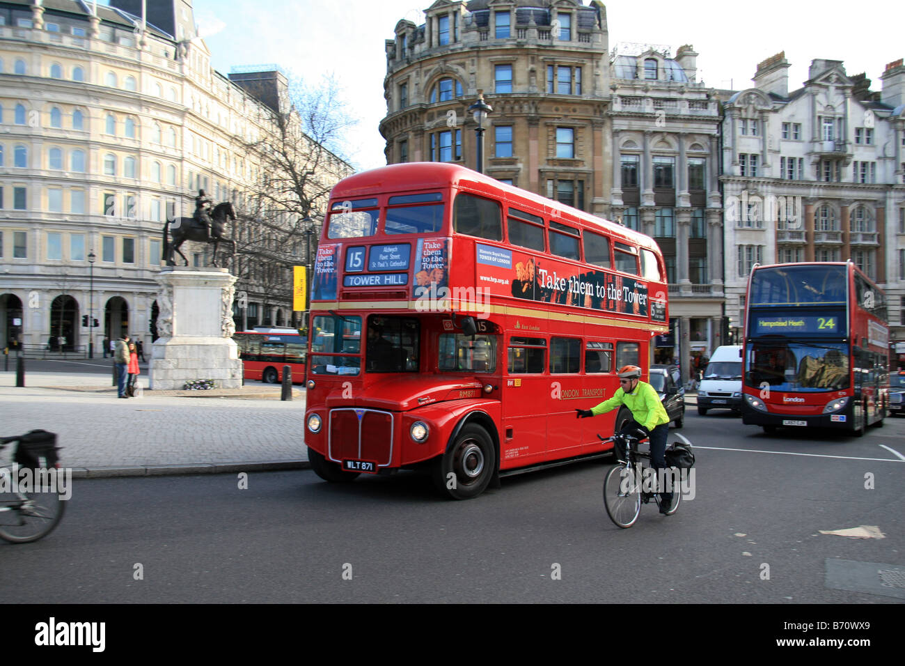 A London Transport Routemaster bus and cyclist manouvering a busy junction around Trafalgar Square, London. Stock Photo