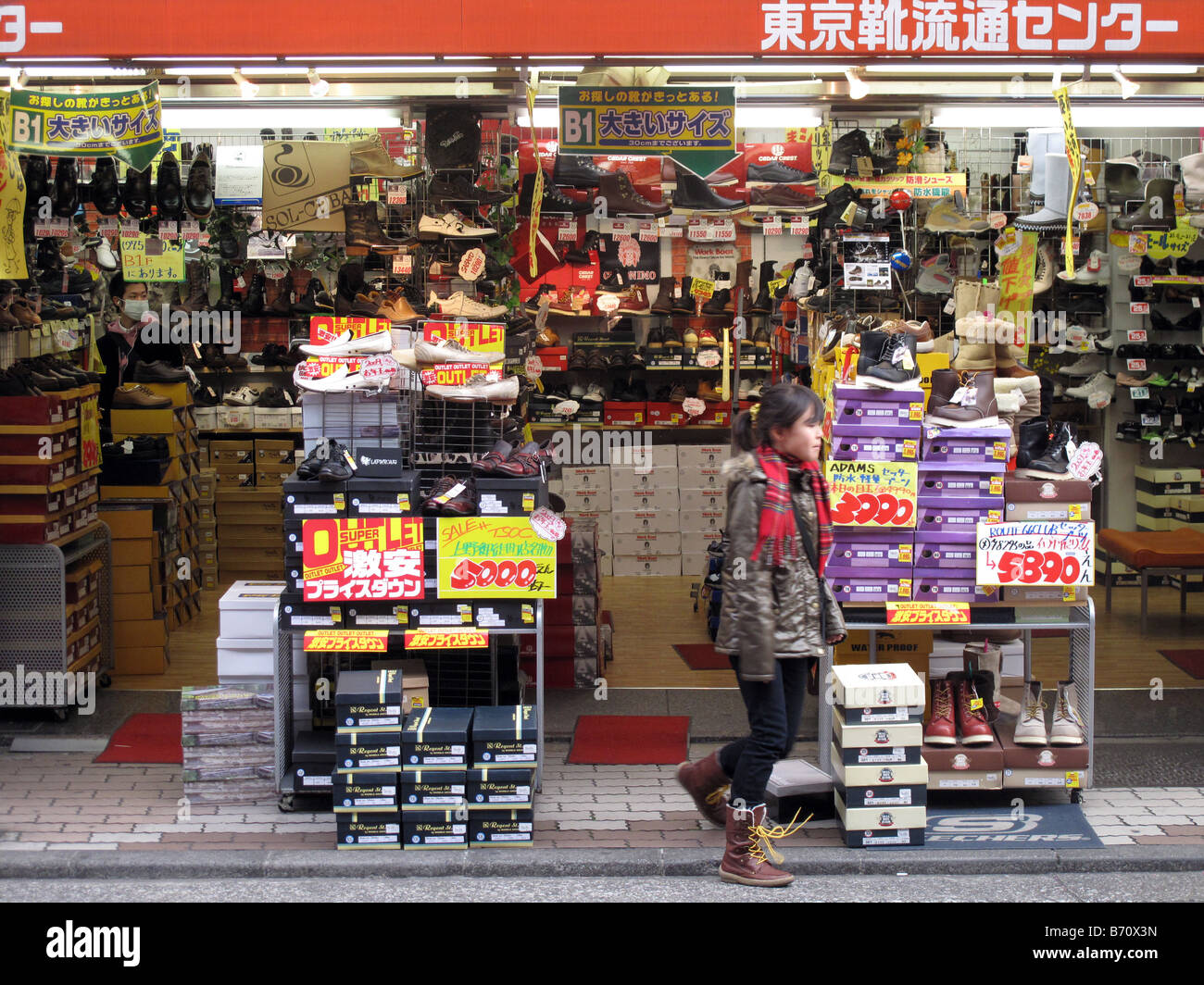 girl walks past a discount shoe store 