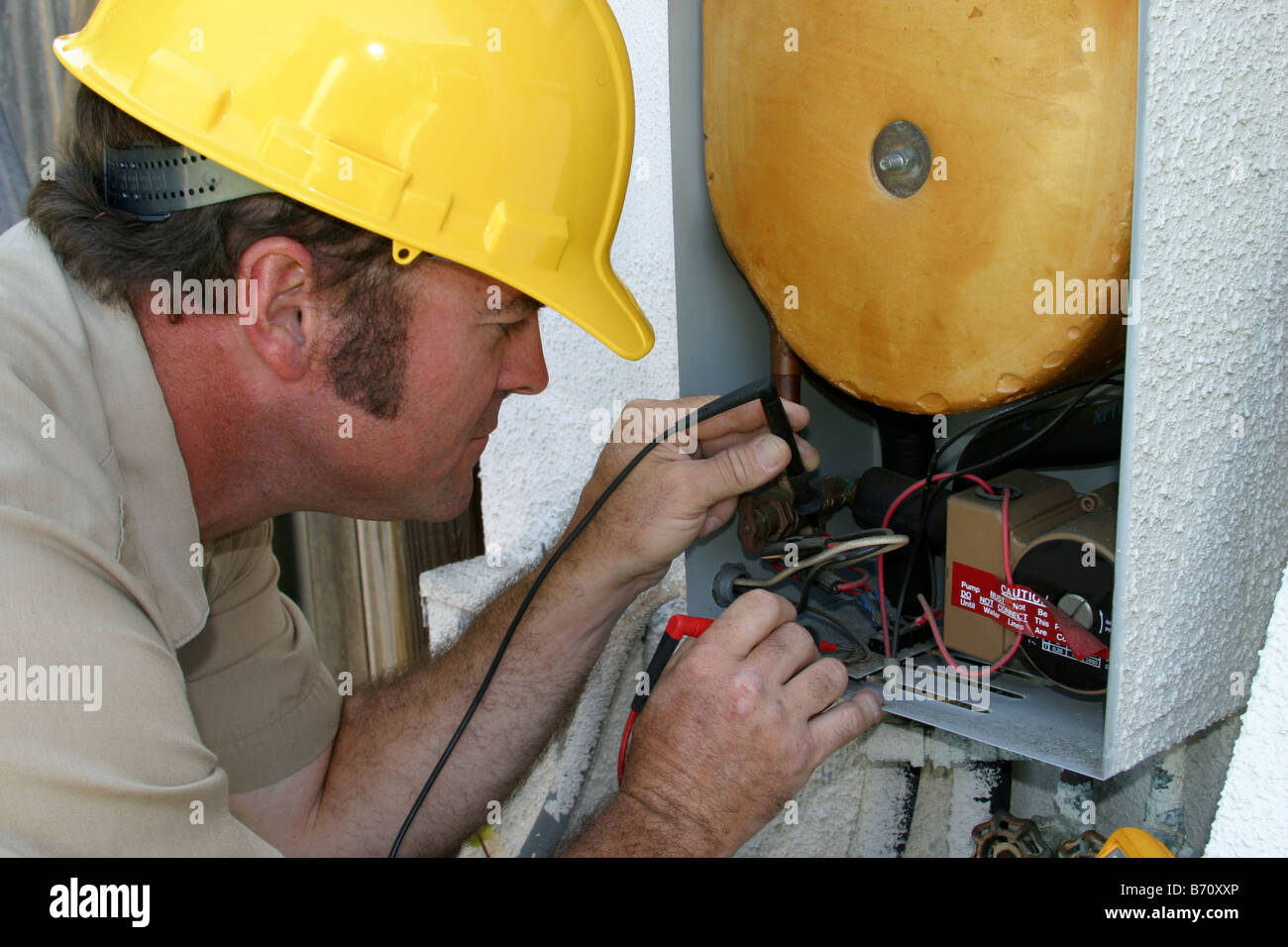 An air conditioning repairman testing a heat recovery unit Stock Photo