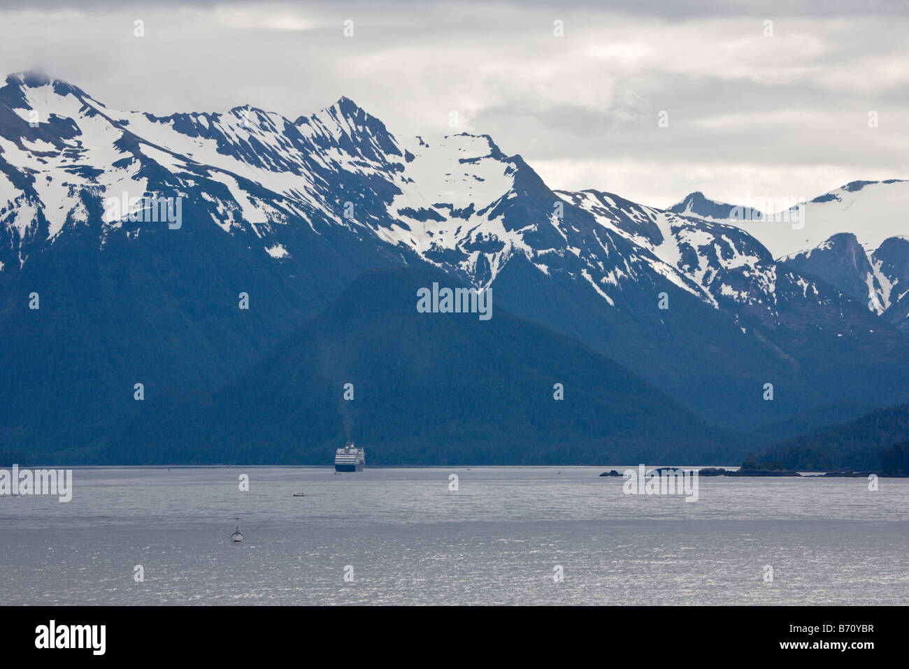 Cruise ship diminished by large mountains sailing the Inside Passage from Seattle to Alaska Stock Photo