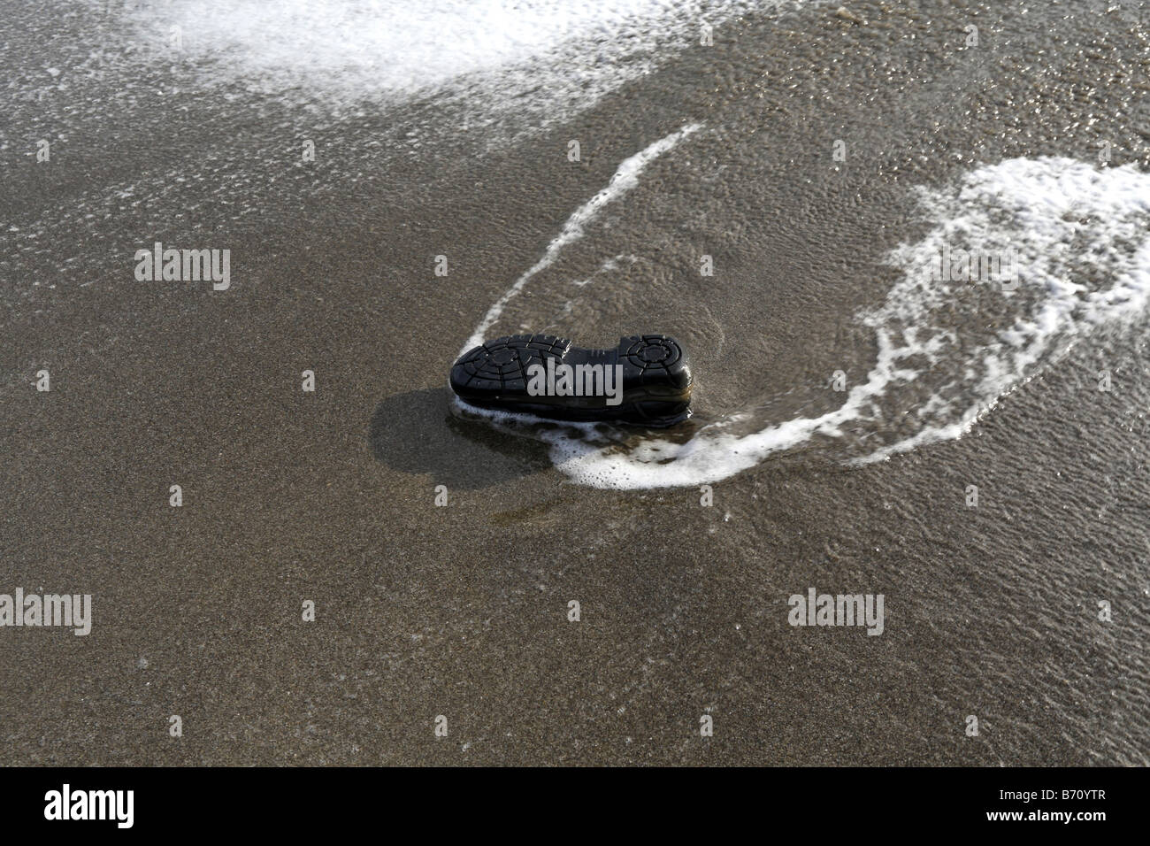 Mans Shoe Washed Up on Beach Stock Photo
