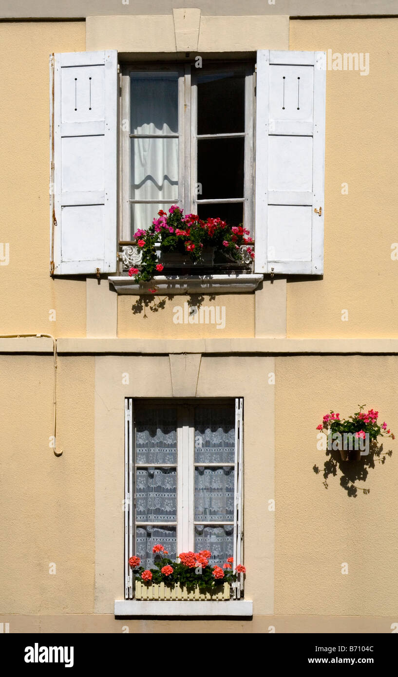 Traditional French windows with shutters and window boxes with flowers Stock Photo