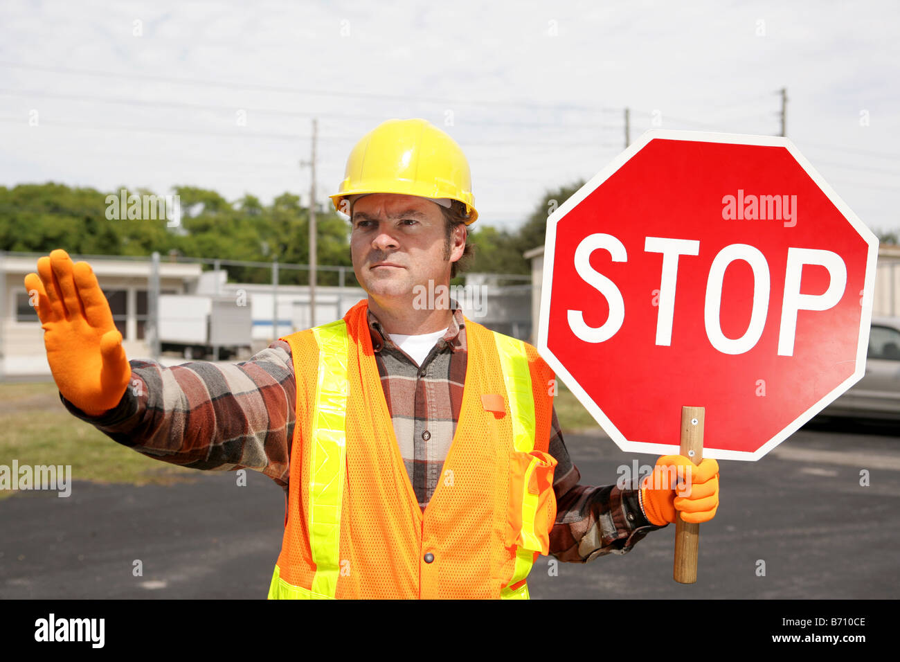 A construction worker holding a stop sign and directing traffic Stock