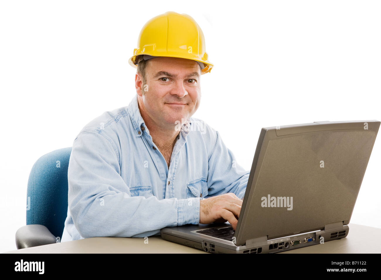 Friendly contractor in his office reviewing the plans on his computer ...