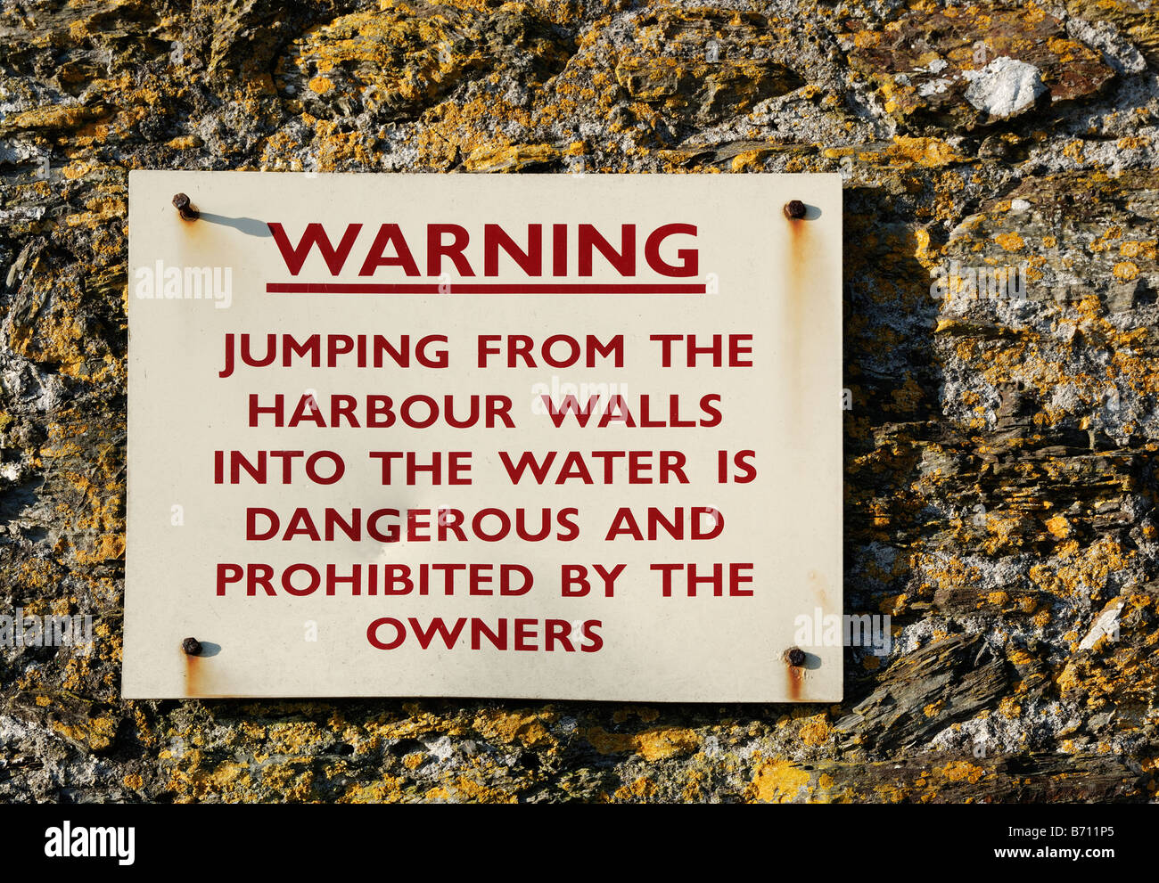 a sign warning people about jumping from the harbour walls at charlestown,cornwall,uk Stock Photo