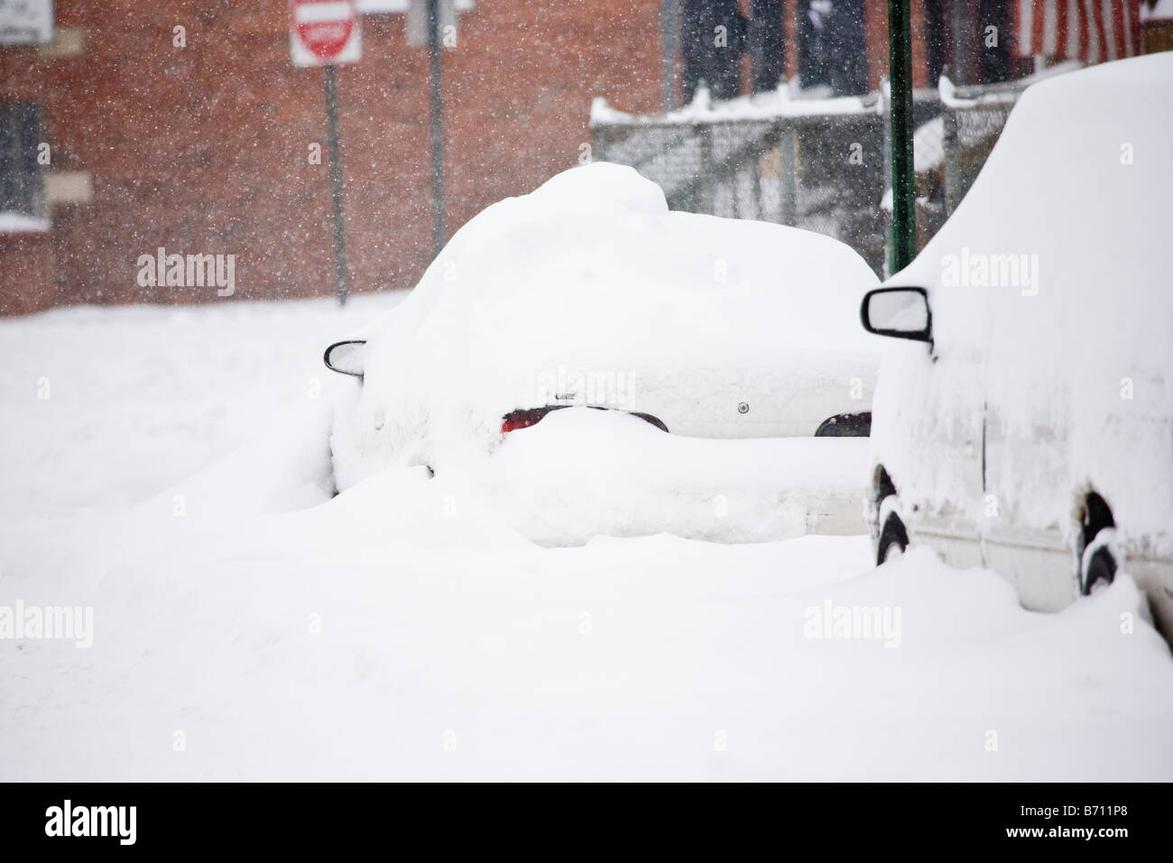 Cars parked along the street during a snow storm Stock Photo