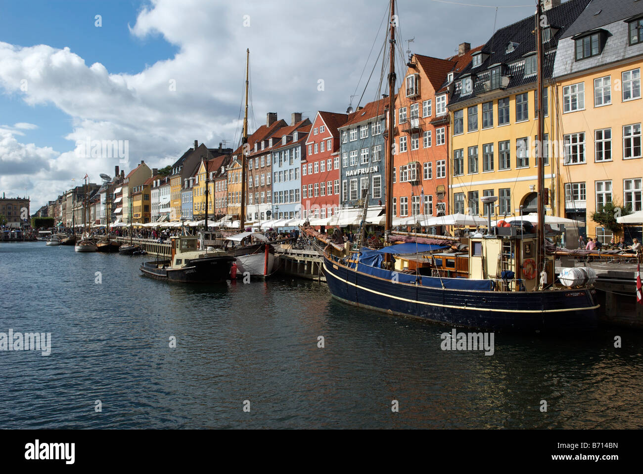 Boats and colourful buildings with waterfront cafes and restaurants Nyhavn Copenhagen Denmark Stock Photo