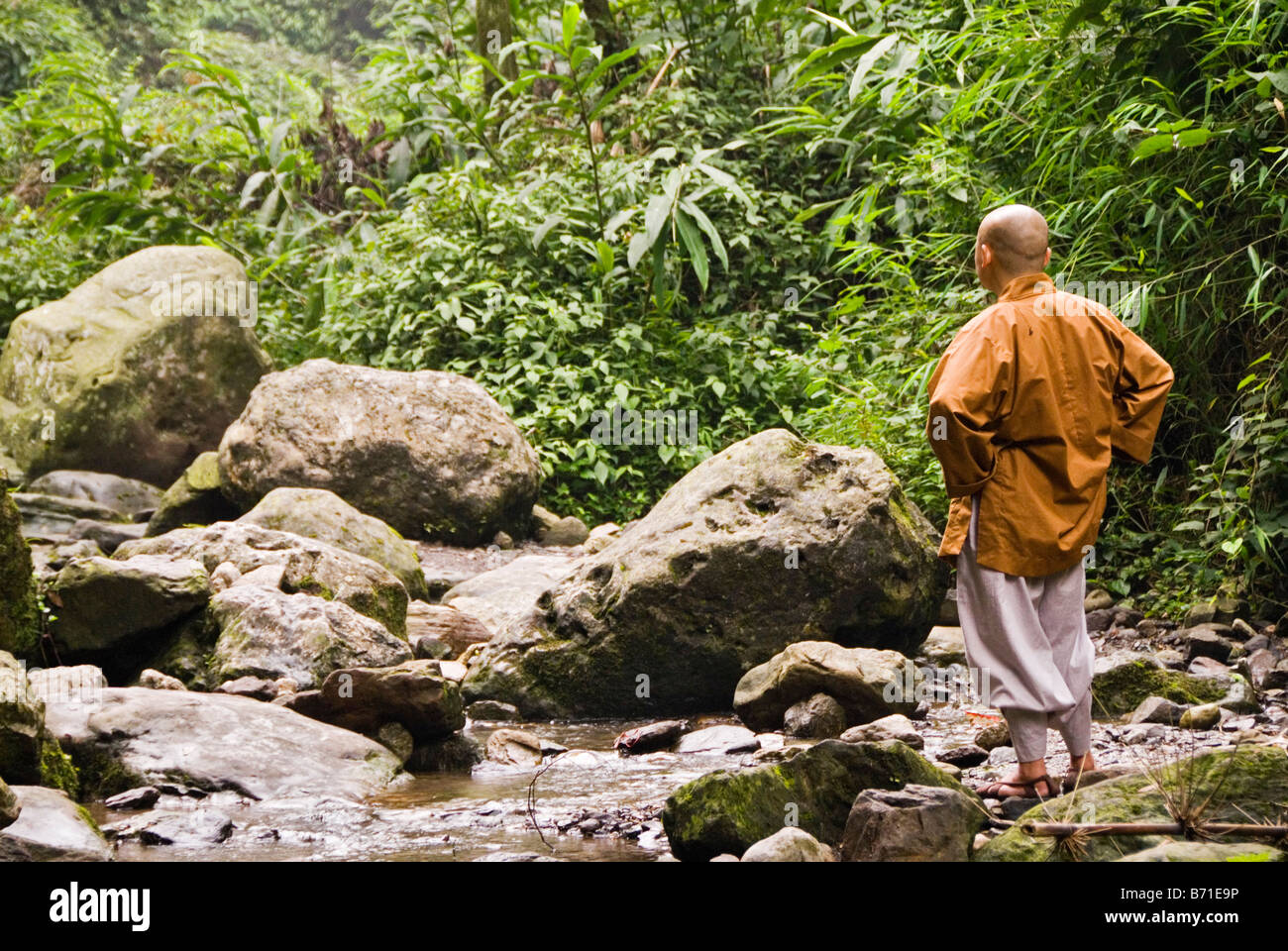 Budhist monk meditating nearby a river Emei Shan Sichuan China Stock Photo