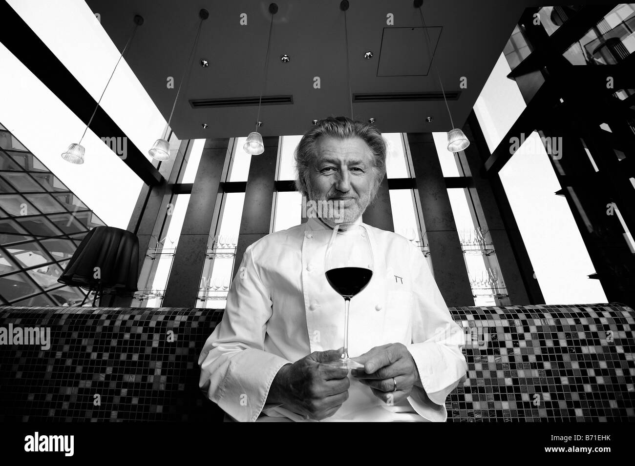 French chef Pierre Gagnaire poses with a glass of wine at his restaurant in Tokyo Japan Stock Photo
