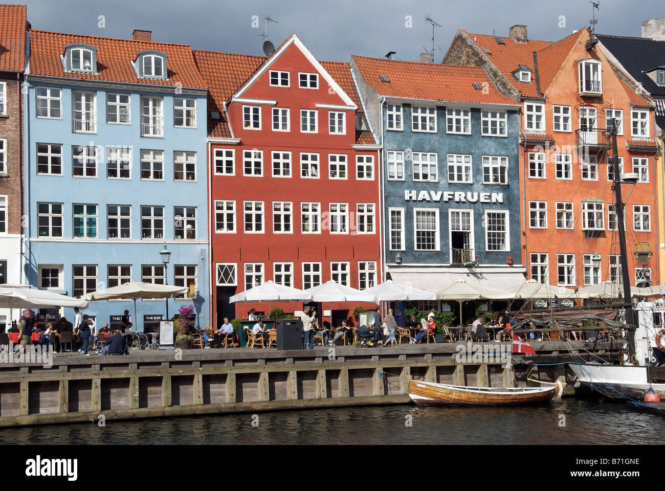 Boats and colourful buildings with waterfront cafes and restaurants Nyhavn Copenhagen Denmark Stock Photo