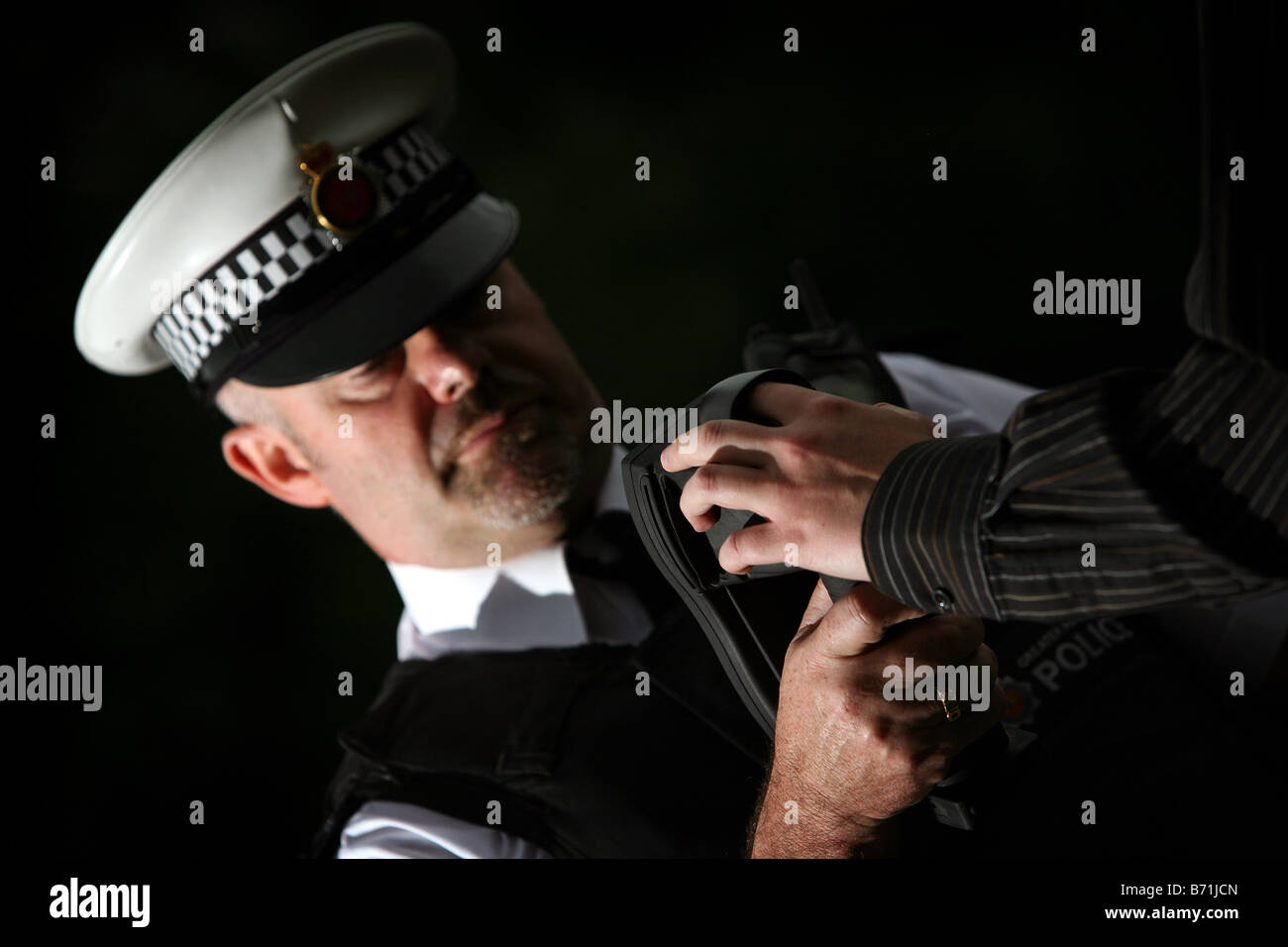 a police officer uses a portable finger printing device Stock Photo