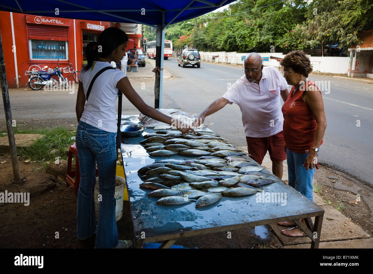 Young girl selling fresh fish from a roadside stall in Mauritius Stock Photo