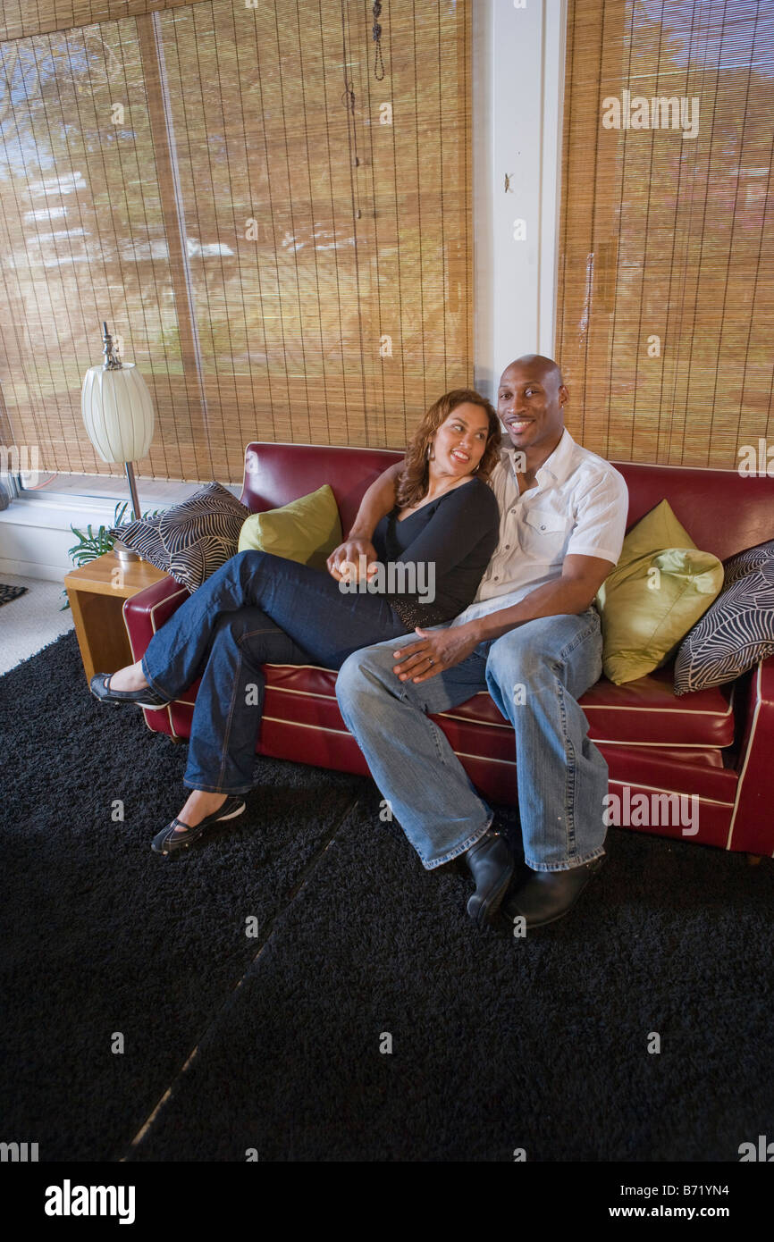 Happy African American couple sitting on living room couch Stock Photo ...