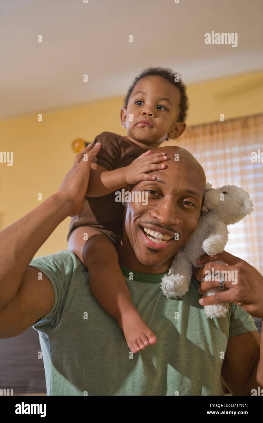 Happy African American father holding son on shoulders Stock Photo - Alamy