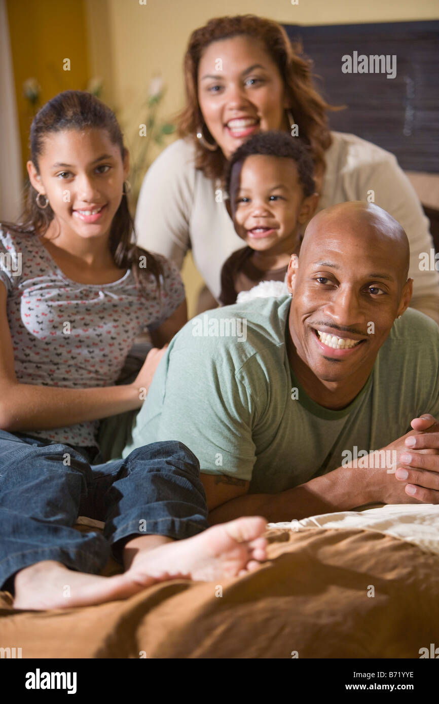 Happy African American family relaxing on bed together Stock Photo Alamy