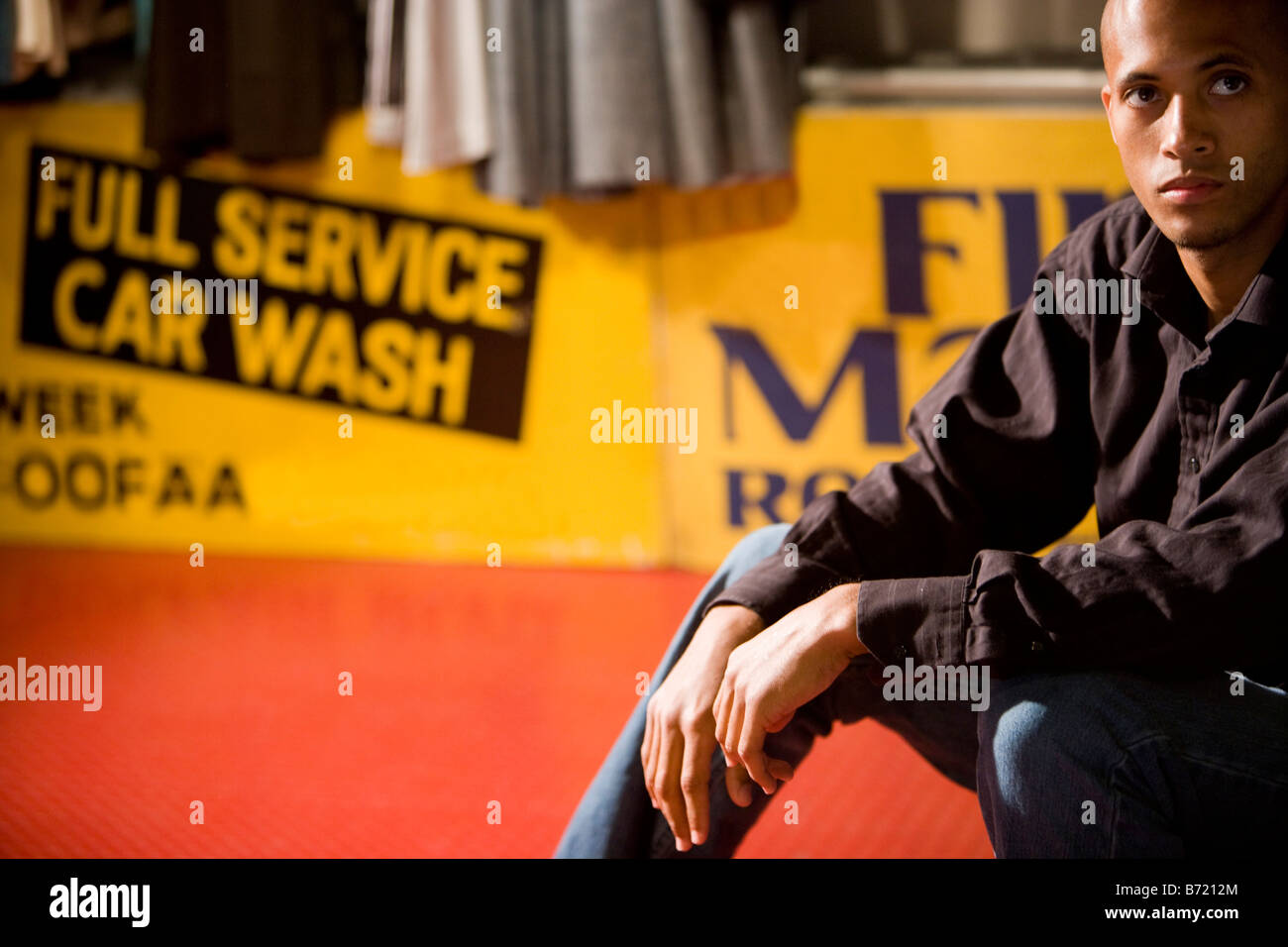 African American man sitting in front of sign Stock Photo