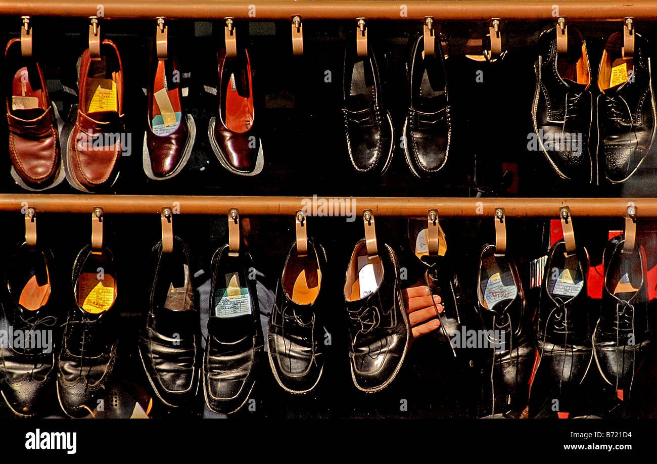 Shoes hang in the window at a shoe repair shop in Boston Massachusetts Stock Photo