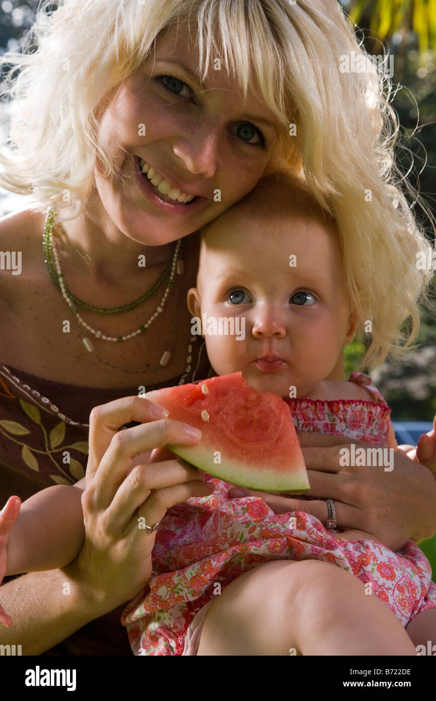 Mother feeding watermelon to baby Stock Photo Alamy