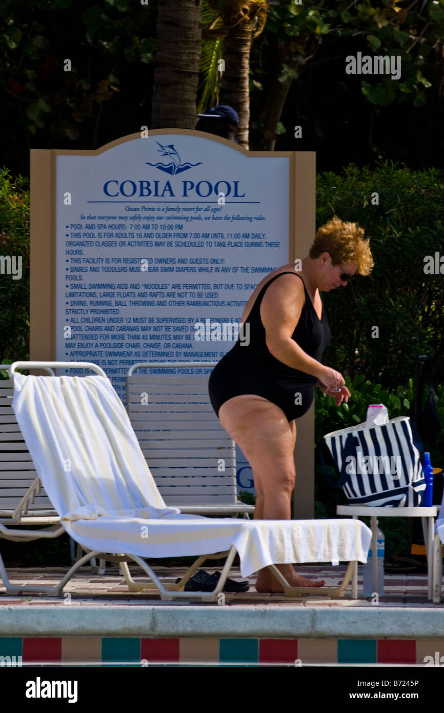 Palm Beach Shores , swimming pool , elderly large portly lady in sunglasses & black bathing costume USA Stock Photo