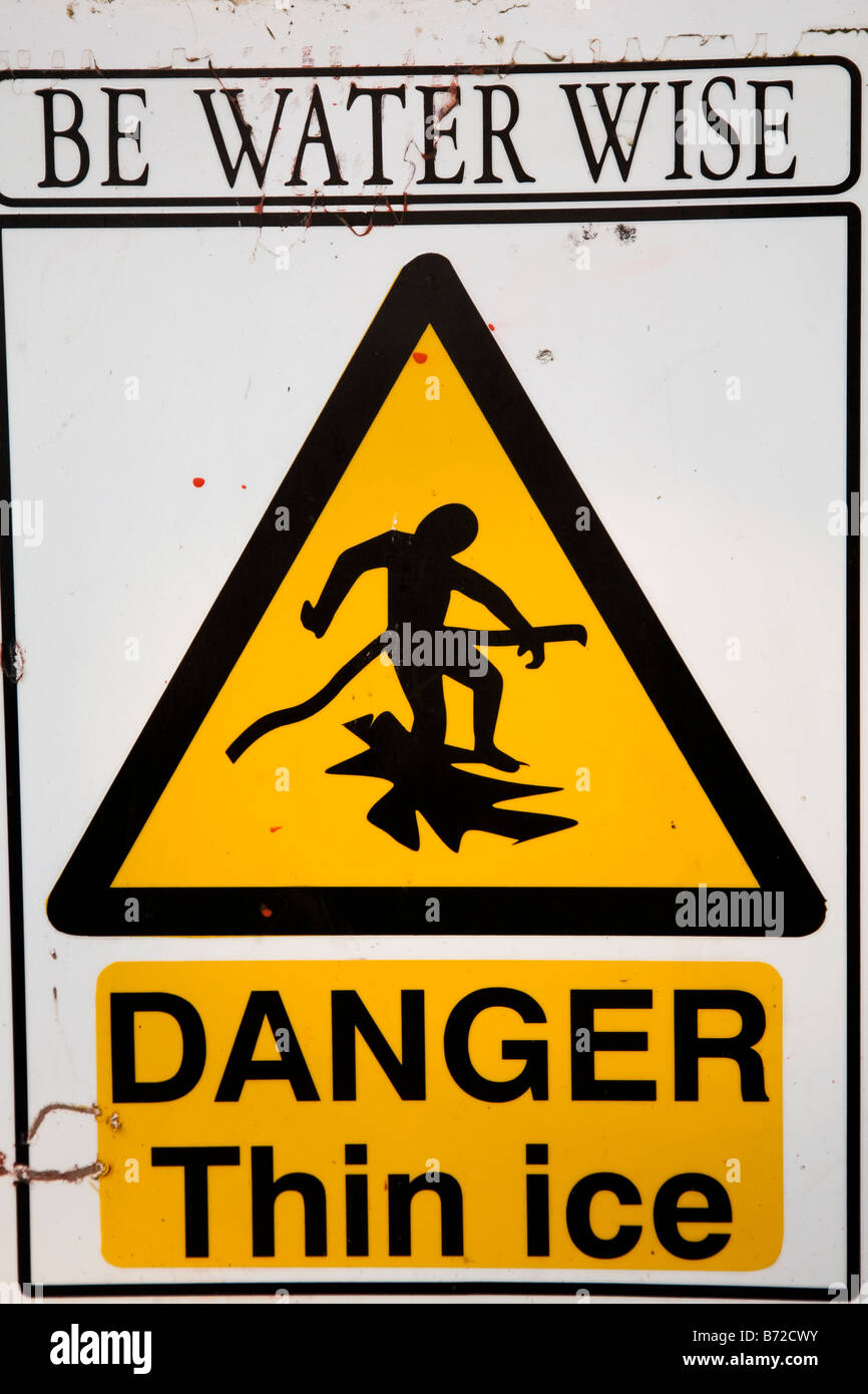 A sign states "danger thin ice". Stock Photo