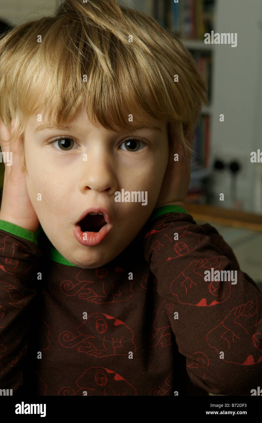 A young boy covering his ears Stock Photo Alamy