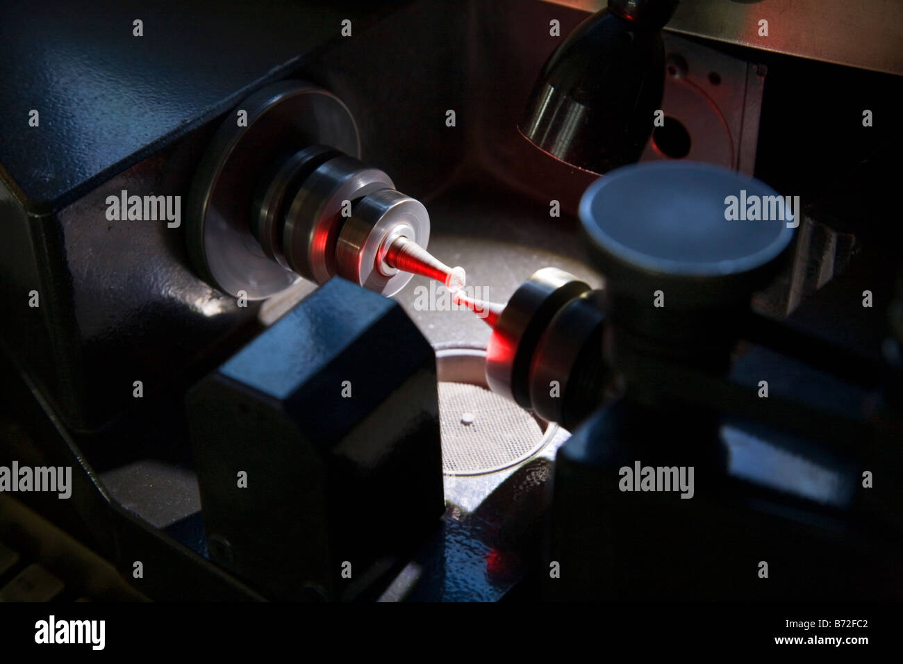 Diamond cutting machine cutting a spinning diamond. Diamond in