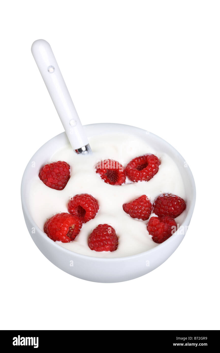 Raspberries and cream in bowl cut out on white background Stock Photo