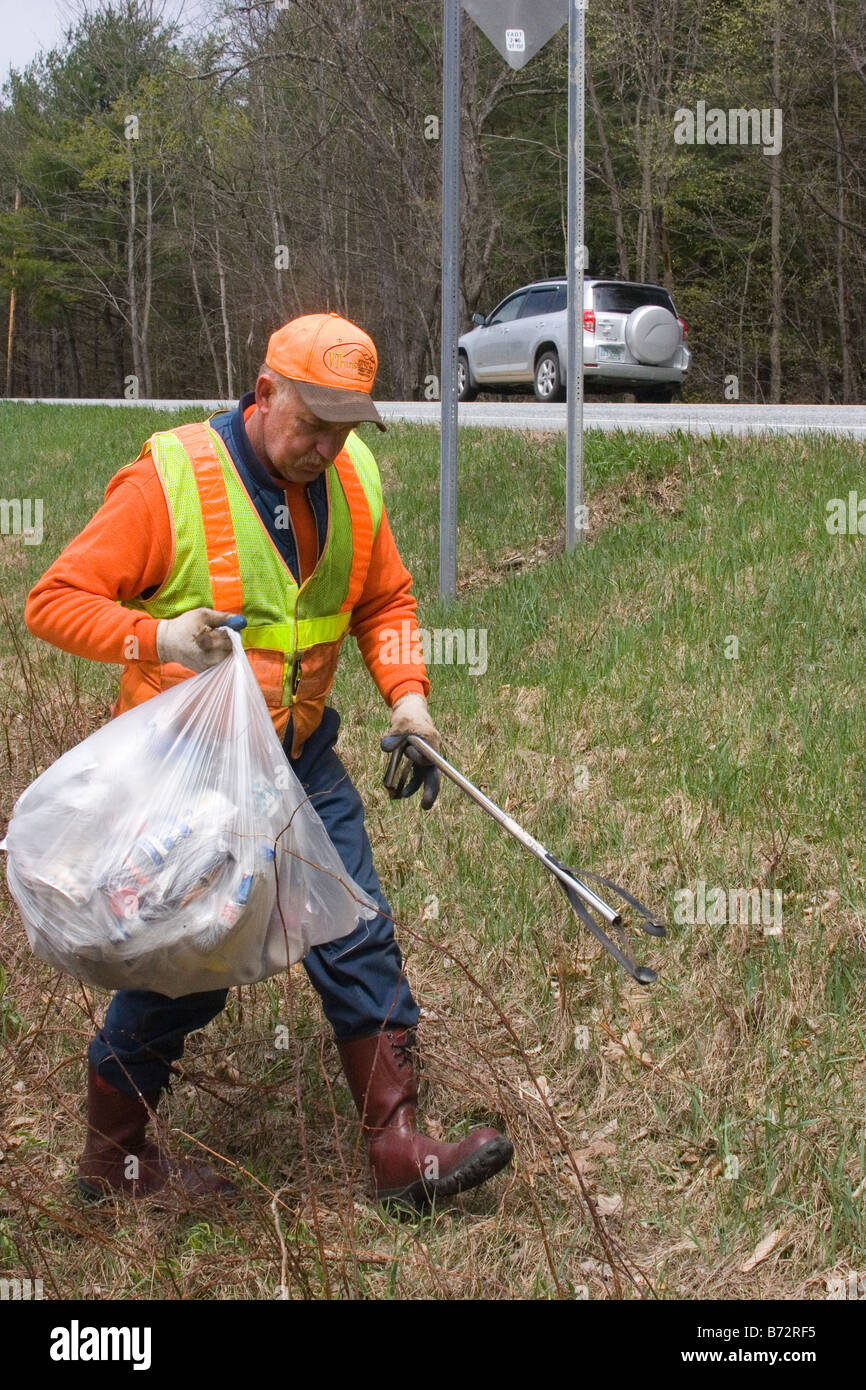 County utility worker picks up litter alongside highway Stock Photo Alamy