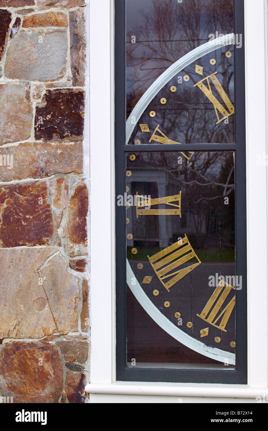 An antique clock face in the window of a country historical society ...