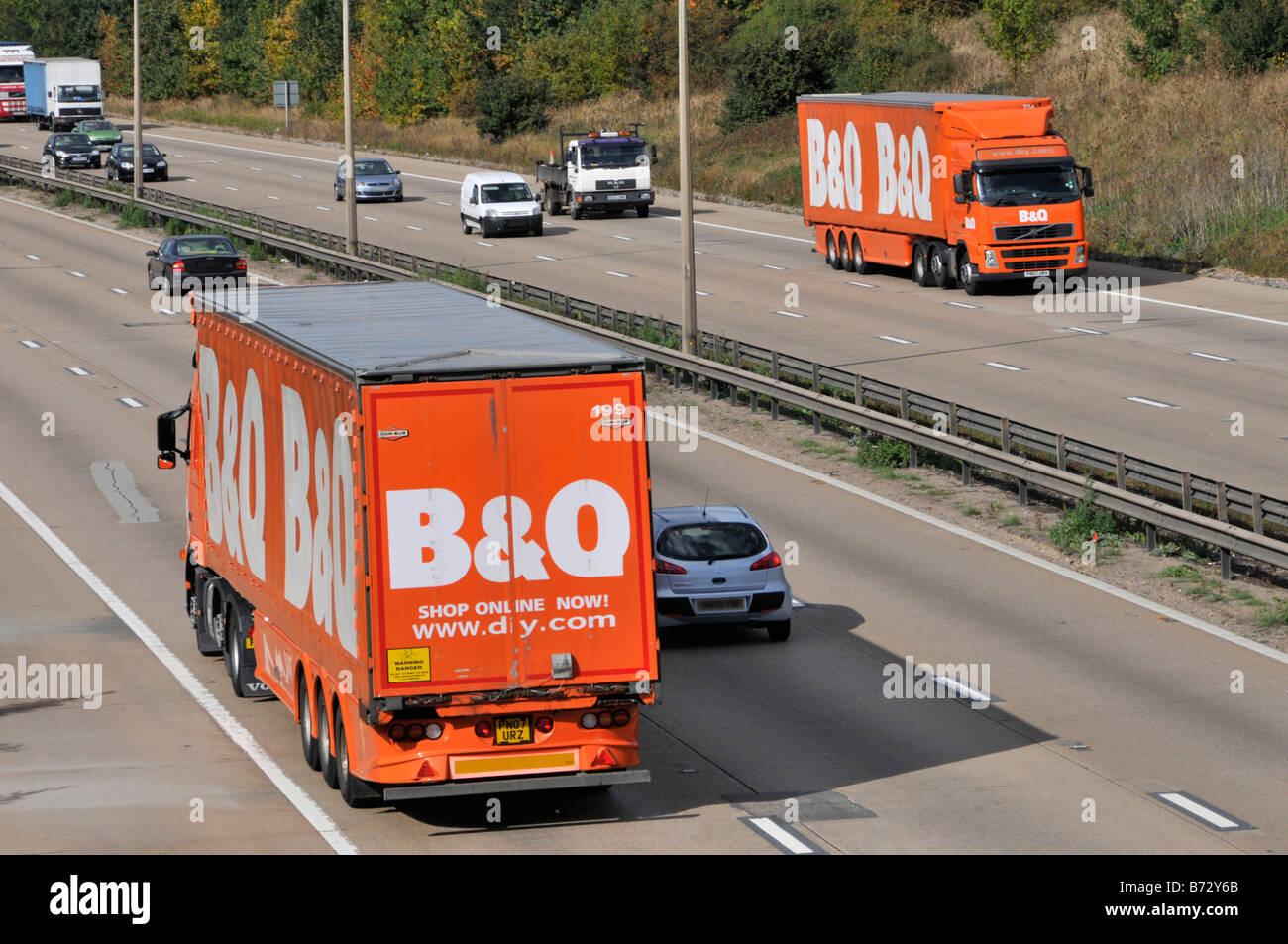 M25 motorway two B&Q DIY store delivery lorries passing on motorway