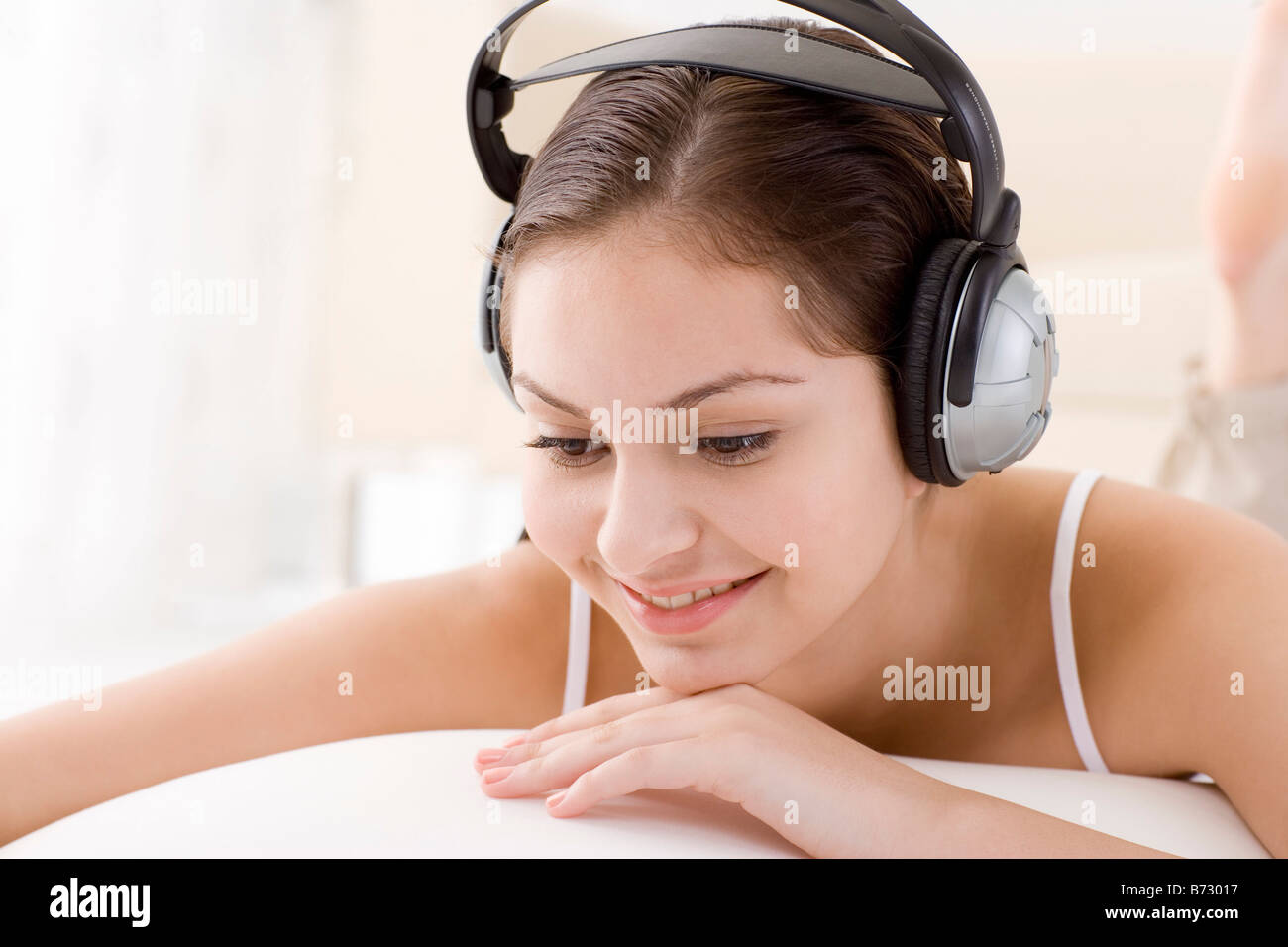 Teenage girl lying on bed wearing headphone Stock Photo Alamy