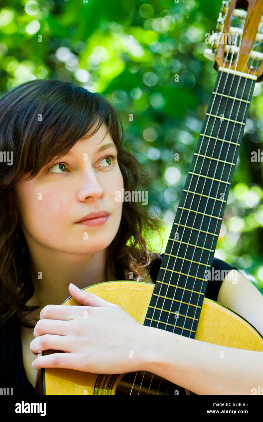 Young woman holding her classic guitar Stock Photo - Alamy