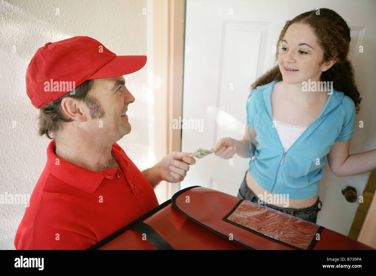 A pizza delivery man collecting payment from a customer focus on driver