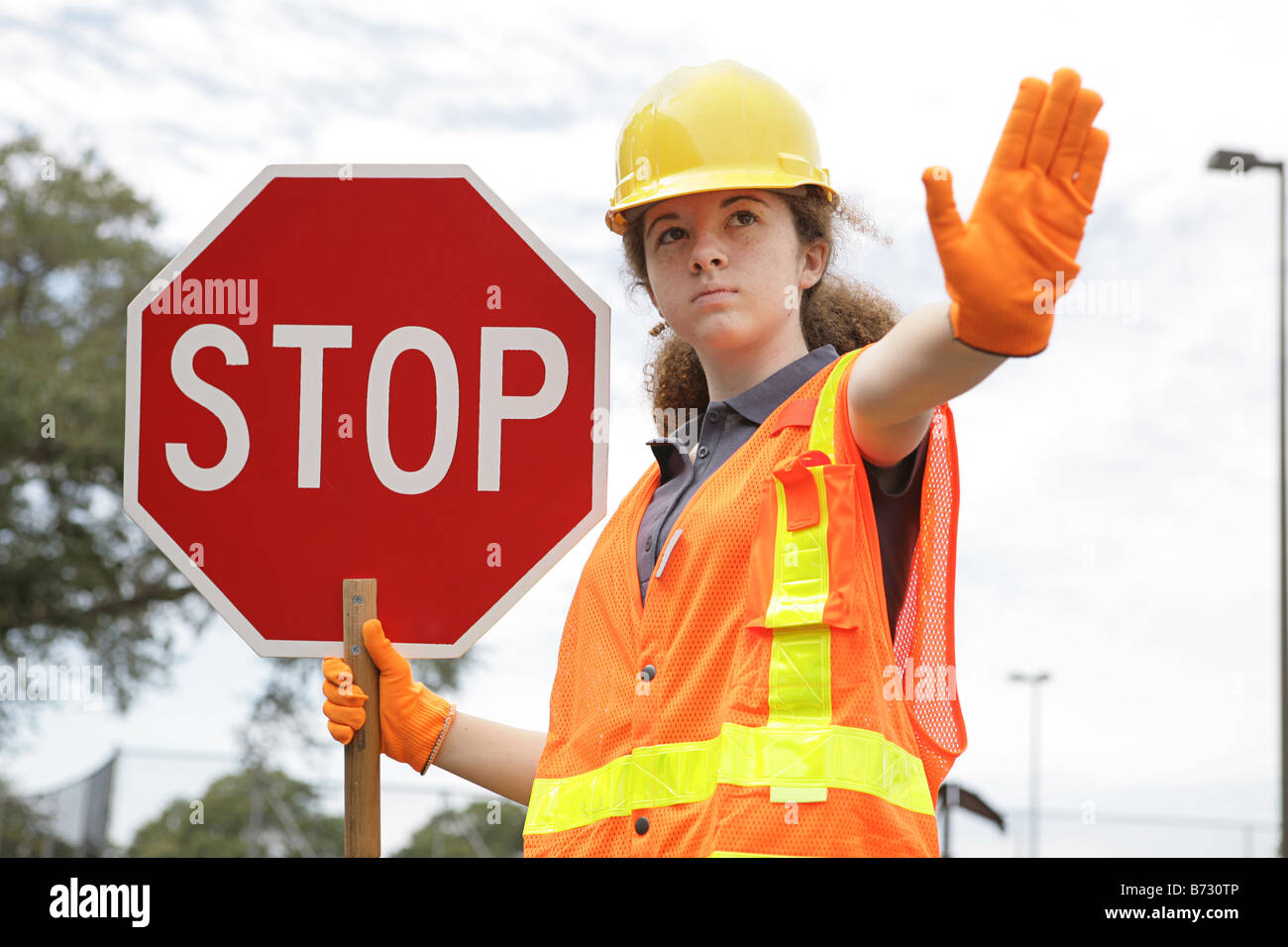 A female construction worker holding a stop sign Stock Photo - Alamy