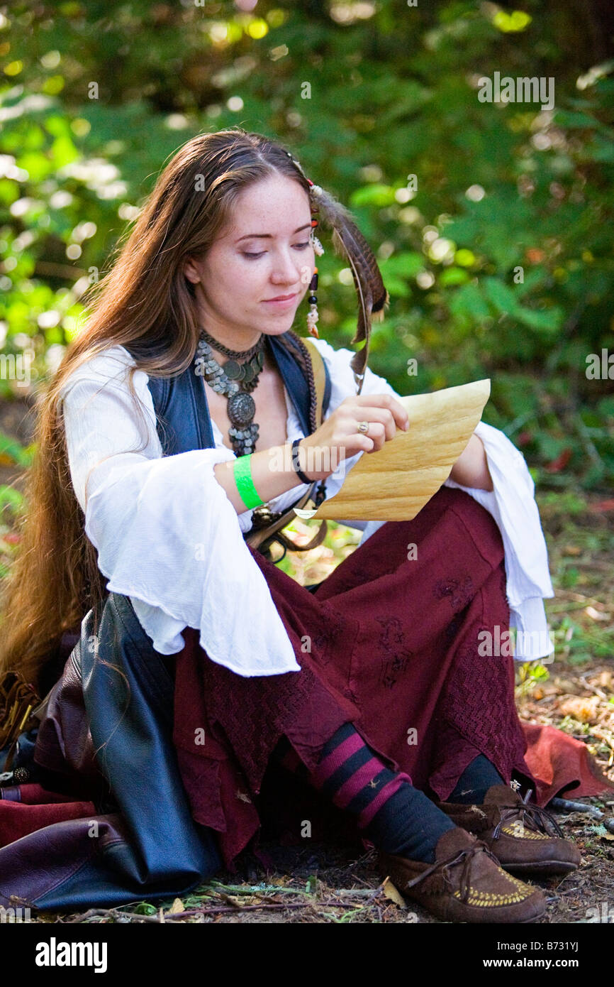 Image of a young woman dressed in Medieval clothing sitting on the ...