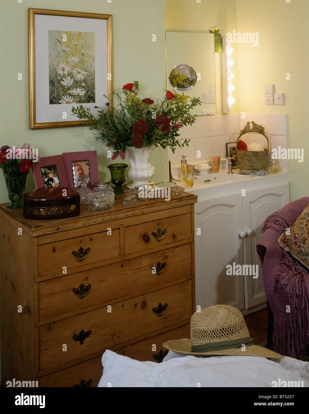 Floral Picture Above Antique Chest Of Drawers In Bedroom With