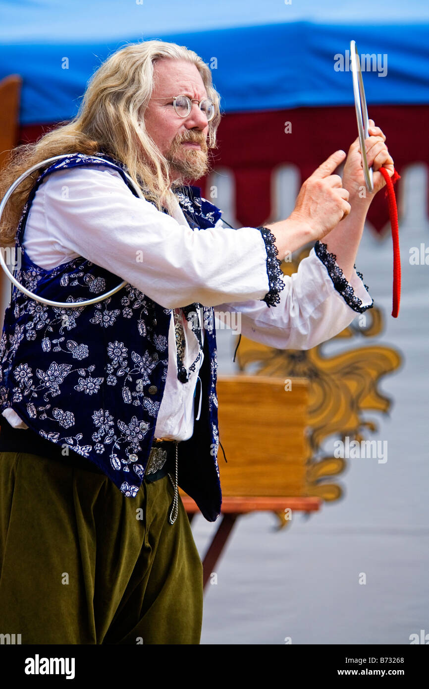 Image of a man dressed as a magician doing a trick with metal rings Stock Photo