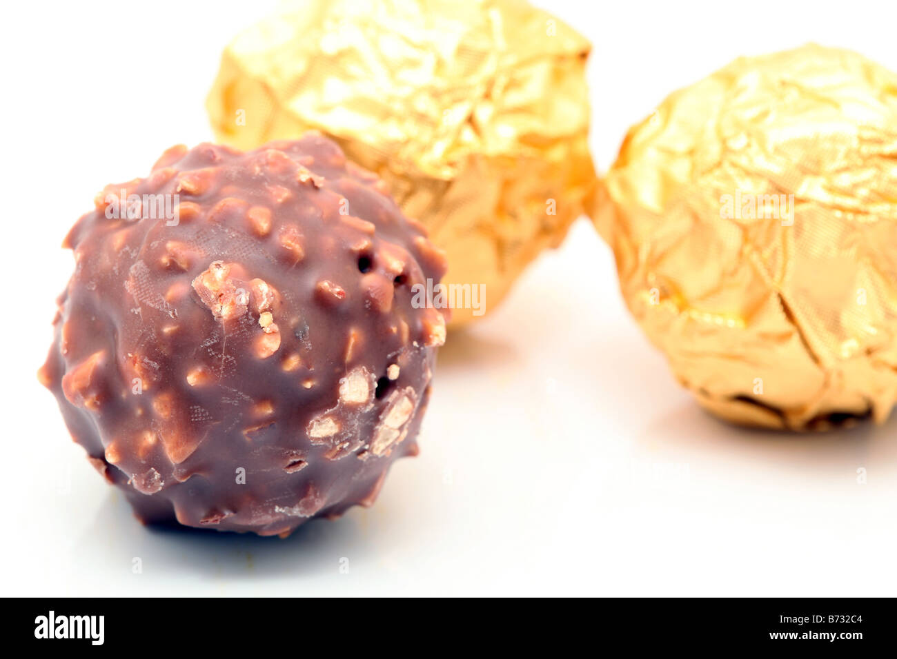 closeup chocolate sphere with nuts with gold wraped defocus background Stock Photo