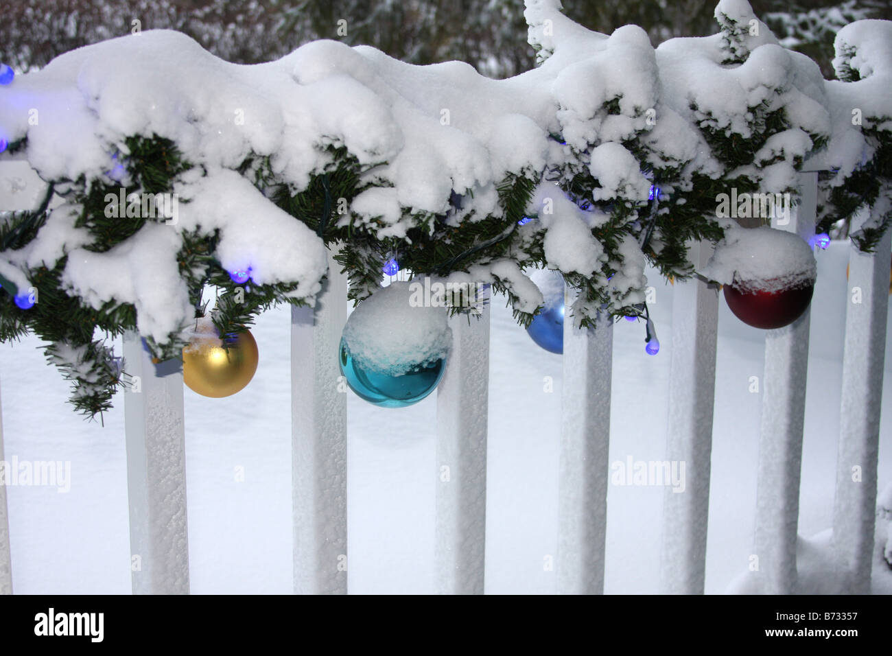A porch with Christmas decorations lights and ornaments covered in snow Stock Photo