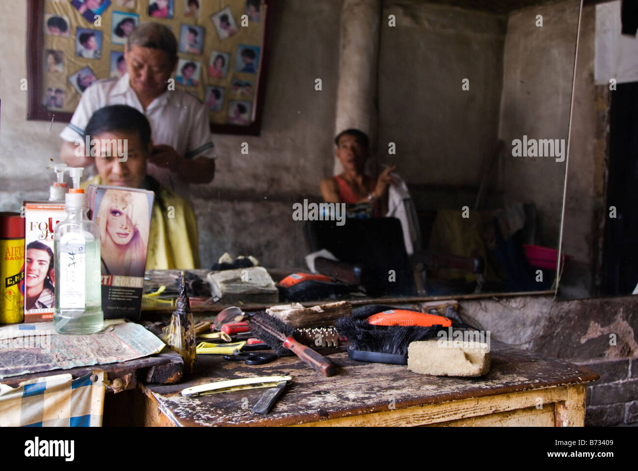 Hairdresser working in his old salon Pingyao Shanxi China Stock Photo