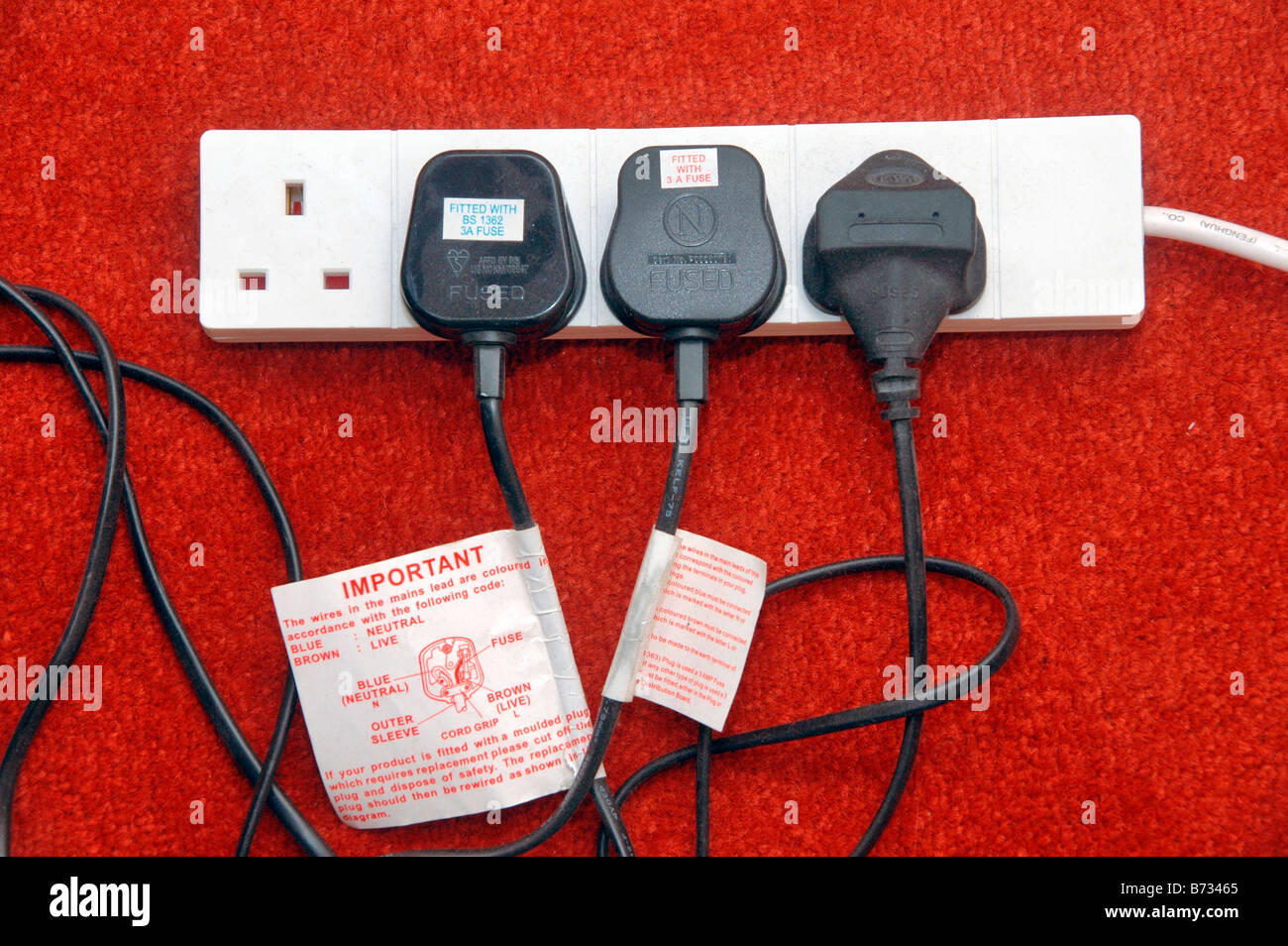 A four plug extension lead with three plugs connected to it Stock Photo