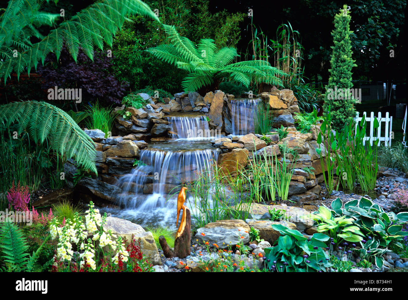 Attractive water garden with waterfalls and tree ferns Stock Photo