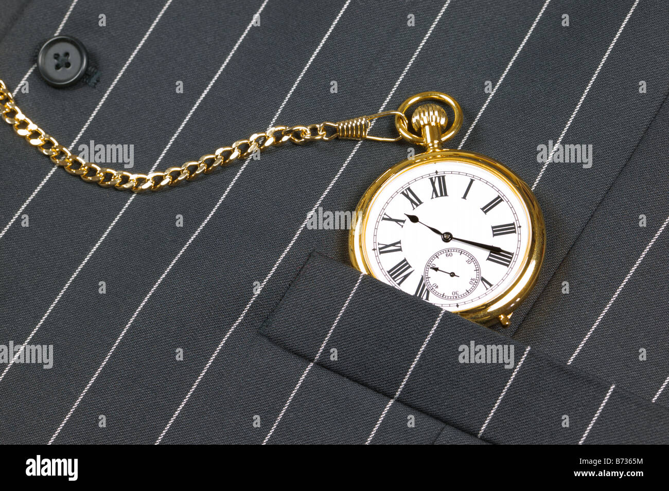 Gold pocket watch with roman numerals in the pocket of a waistcoat Stock Photo
