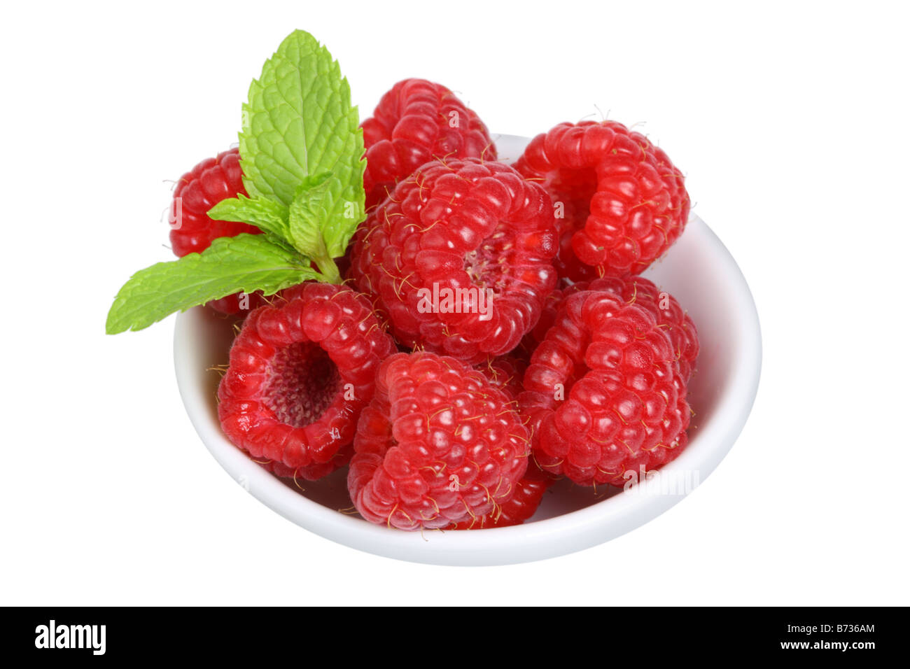 Bowl of red raspberries cut out on white background Stock Photo