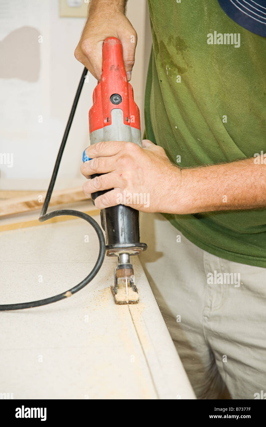 Contractor cutting through laminate counter top with a reciprocating