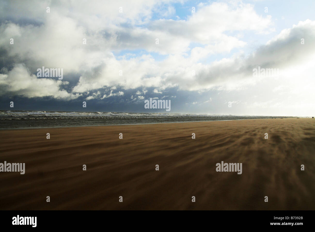 Winter day at the coast, dark storm clouds approaching, the wind whipping up the sand. Landscape picture of Lincolnshire. Beach Stock Photo