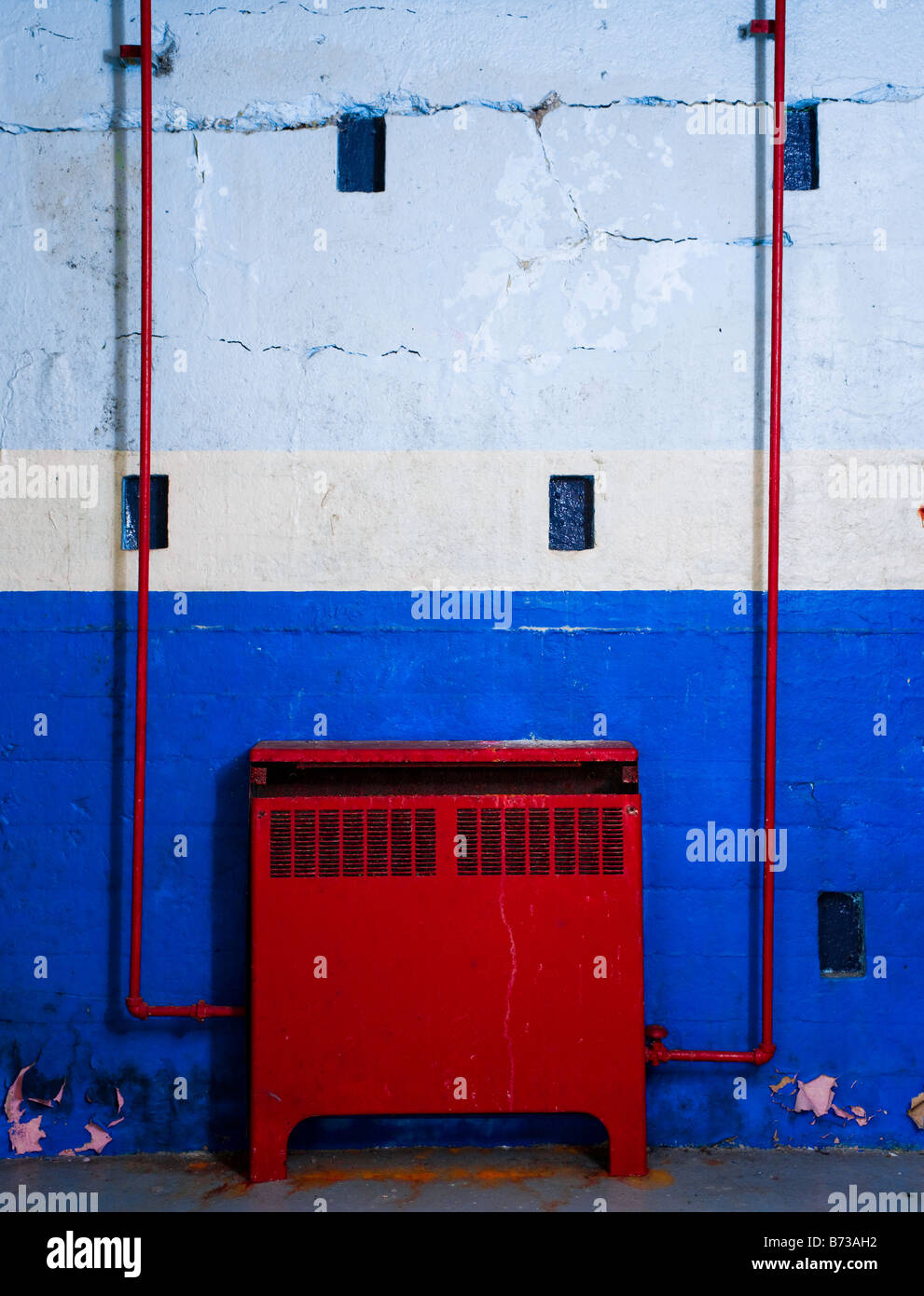 A red hot water radiator heater against a blue wall Stock Photo Alamy