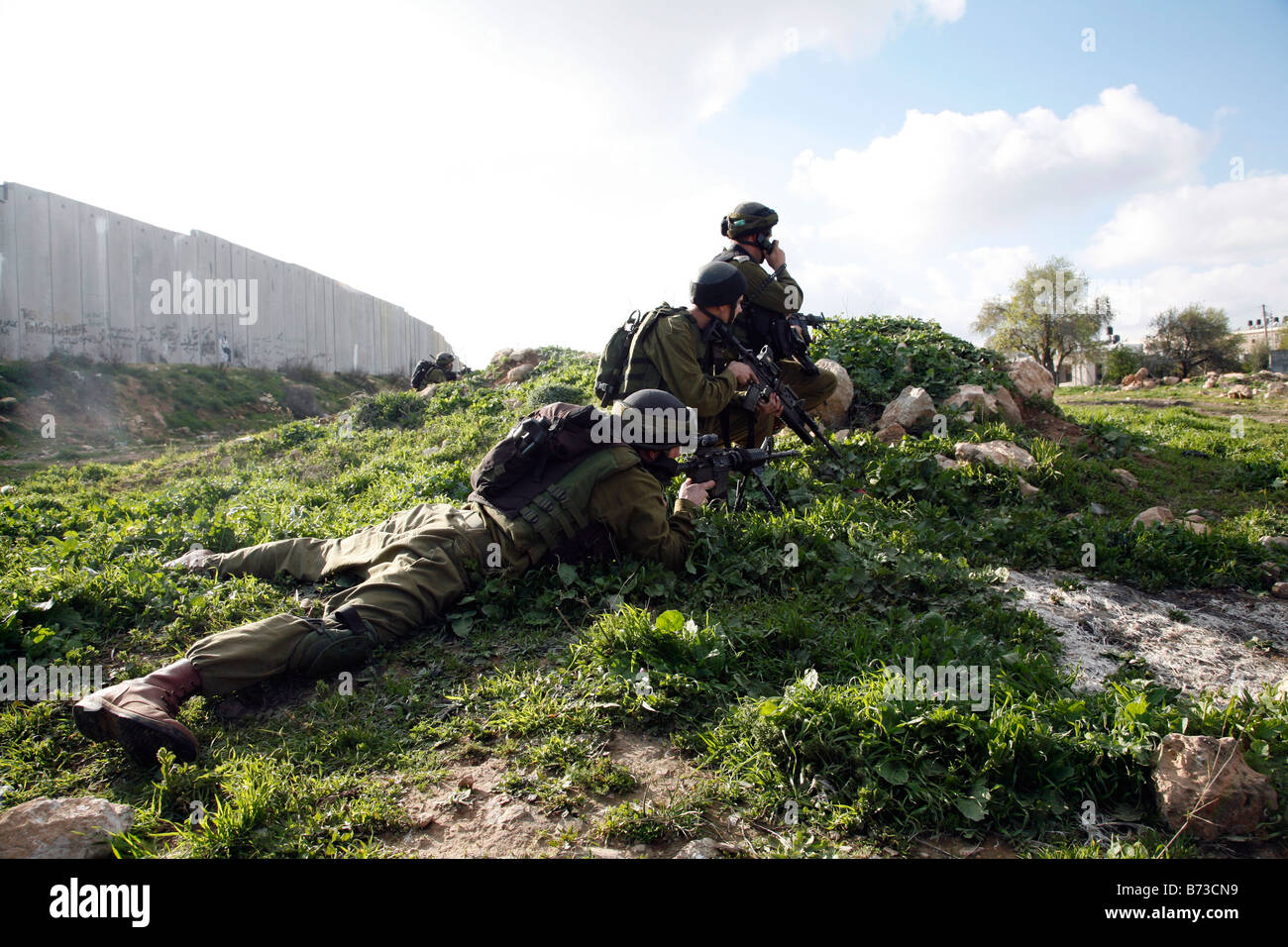 Israeli soldiers shooting rubber bullets at Palestinian stone throwers near the separation barrier in the West Bank. Stock Photo